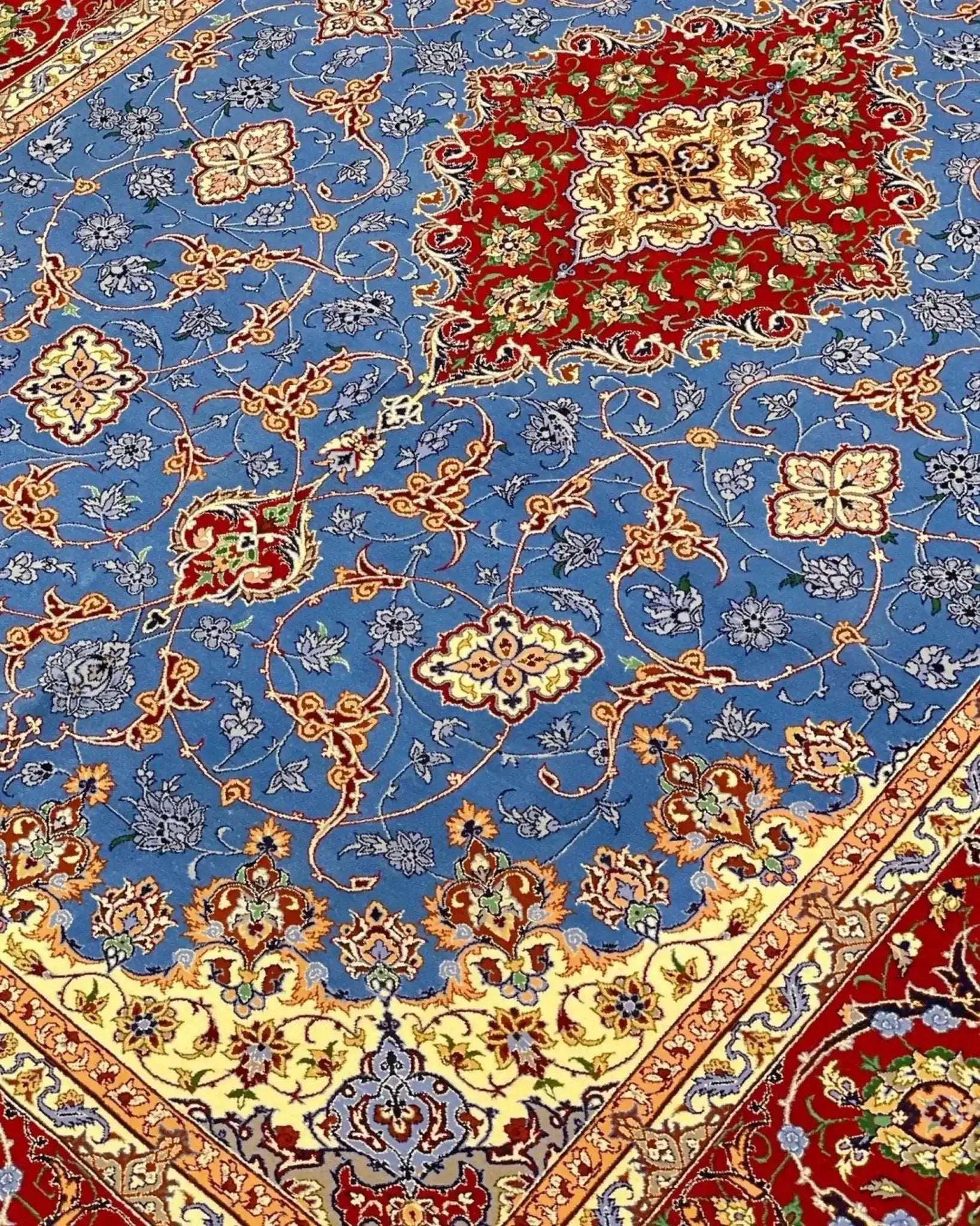 "Decorative wool and silk Persian rug, crafted by Saieed Davarie, with beautiful blue and red floral patterns, new and in stock."